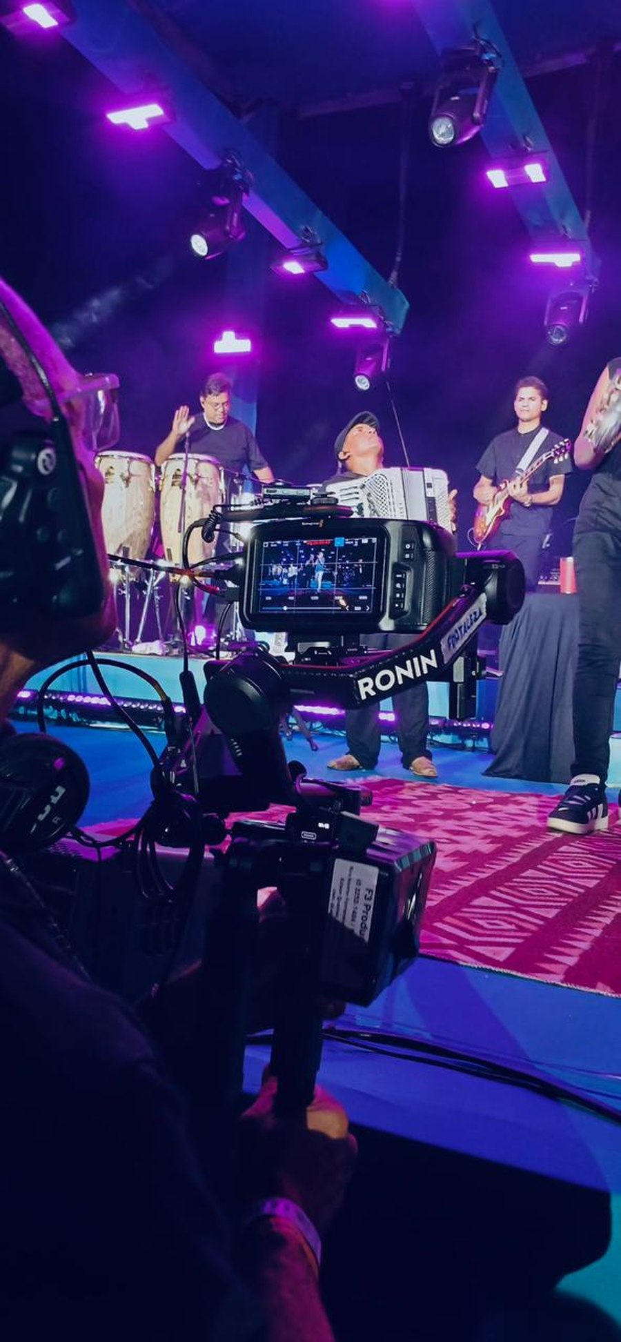 Cinegrafista com estabilizador gimbal captando banda ao vivo